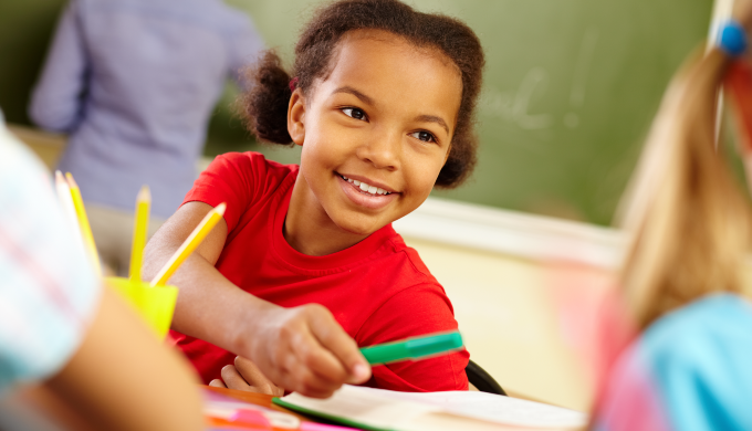 Young Girl Handing Marker to Other Student